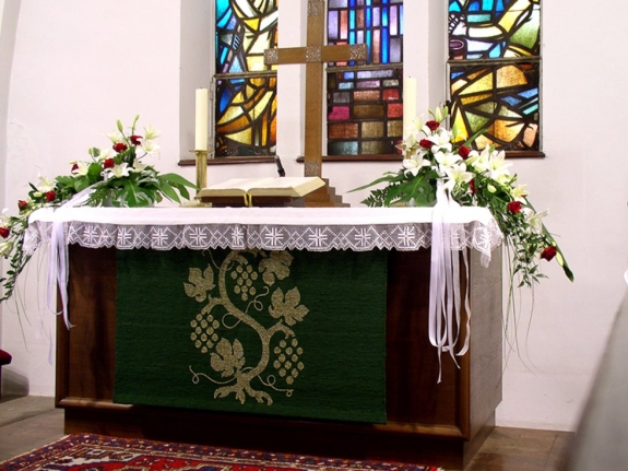 Kirchenschmuck in Weiß und Rot am Altar