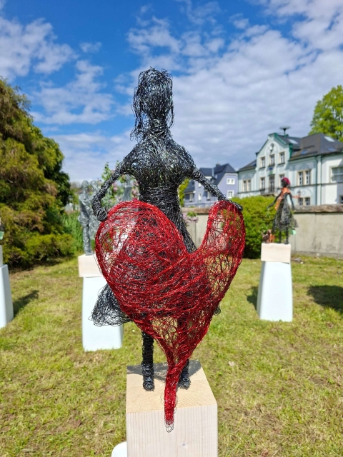 Drahtskulptur einer Frau mit rotem Herz